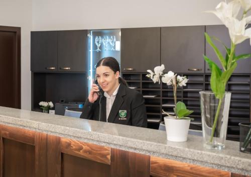 a woman talking on a cell phone in an office at EFI SPA Hotel Superior & Pivovar in Brno