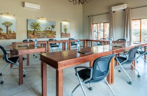 Lions Valley Lodge في نامبيتي جيم ريسيرف: قاعة اجتماعات مع طاولات وكراسي خشبية