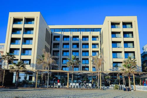 a large building with palm trees in front of it at Royal G Hotel and Spa in Durrës