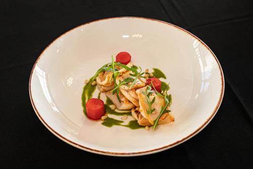 a white plate of food with chicken and vegetables at Royal G Hotel and Spa in Durrës