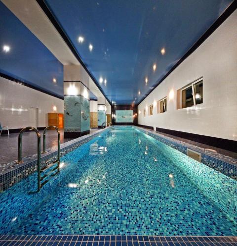 a large swimming pool with blue tiles in a building at Гранд Алексік in Truskavets