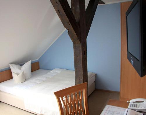 a bedroom with a bed and a desk with a television at Zum Alten Hafen in Rathenow