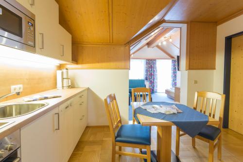 a kitchen and dining room with a table and chairs at Aparthotel am Reitecksee in Flachau
