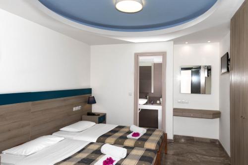 a bedroom with a bed with a blue ceiling at Anna Maria Village in Hersonissos