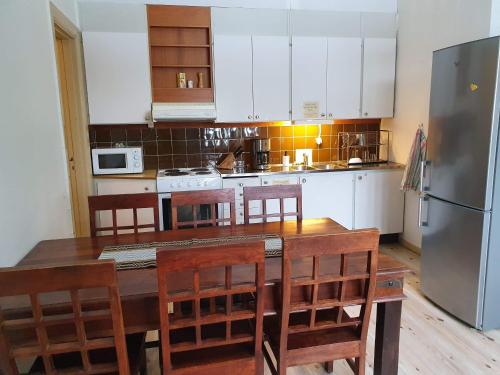 a kitchen with a wooden table with chairs and a refrigerator at Gustafs Logi in Borlänge