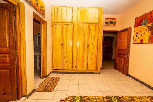 a hallway with a large wooden door in a house at Auberge Africa Thiossane in Saly Portudal
