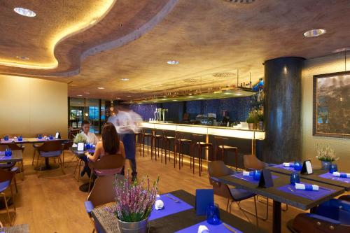 a restaurant with people sitting at tables and a bar at Carlemany Girona in Girona