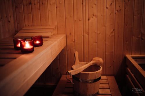 a room with candles and a bucket in a sauna at Le Bonheur de la Cascade 24 pers - Malmedy, wellness, jardin, confort in Malmedy