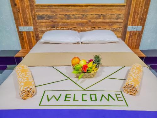 a bed with a welcome sign and a basket of fruit at Dive Villa Thoddoo in Thoddoo