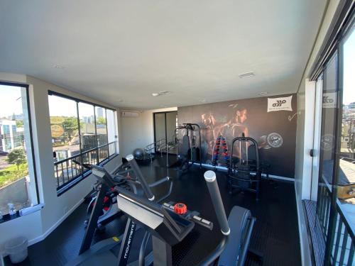 a gym with two tread machines and a wall mural at HD Plaza Hotel in Assis