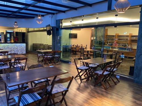 a restaurant with tables and chairs in a room at HD Plaza Hotel in Assis