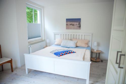 Cama blanca en habitación con ventana en Ferienwohnung Mariechen, en Graal-Müritz