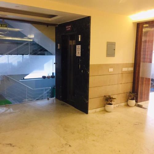 a black door in a room with a wall at Mayda Inn- A Boutique Hotel in New Delhi