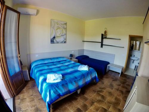 a bedroom with a blue bed and a couch at Agriturismo Eucaliptus in Bolgheri