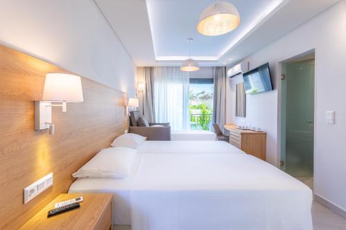 a hotel room with two beds and a television at Anna Maria Village in Hersonissos