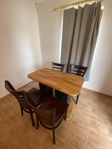 a wooden table and chairs in a room at Chaty a Apartmány Hracholusky Kemp Kosatka in Pňovany