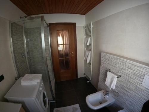une salle de bain avec un lavabo, des toilettes et une douche dans l'établissement Mansarda Bellavista - Your Mountain Holiday, à Premana