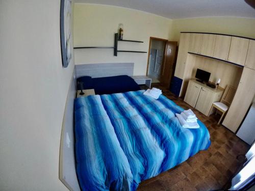 a bedroom with a large blue bed with blue sheets at Agriturismo Eucaliptus in Bolgheri