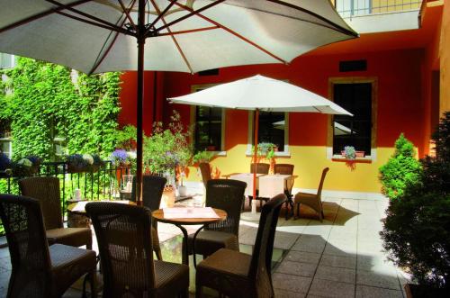 a patio area with a table, chairs, and umbrellas at Art Hotel in Wrocław