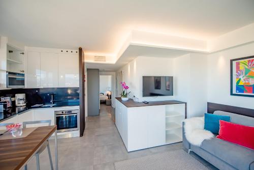 a kitchen and living room with a couch and a table at High Standing with Incredible Old Antibes and Sea views in Antibes