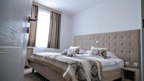 a bedroom with a large bed with a large window at Hotel Consul in Split