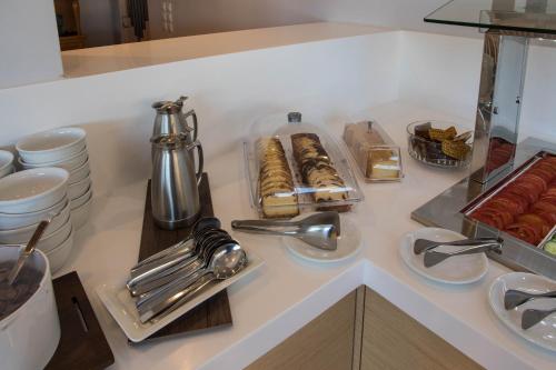 un comptoir blanc avec des pâtisseries et autres articles dessus dans l'établissement Anna Maria Village, à Chersónissos