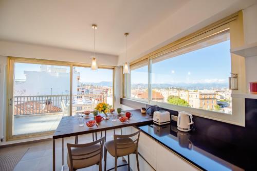 a kitchen with a table and chairs and a large window at High Standing with Incredible Old Antibes and Sea views in Antibes