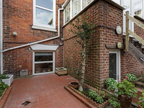 a brick house with a courtyard with plants on it at Stopover at ALBANY GARDEN APARTMENT with great outdoor space in Portsmouth