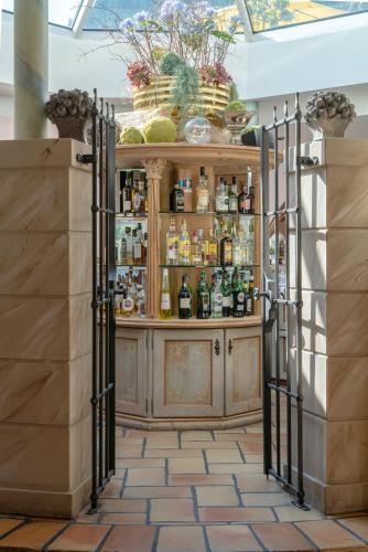 a bar with a wooden cabinet filled with alcohol at Via Salina - Hotel am See - Adults Only in Haldensee