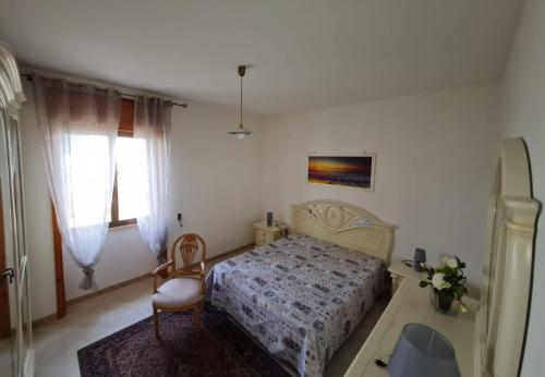 una camera da letto con un letto e una sedia di Amata Villa Vacanza a Leuca