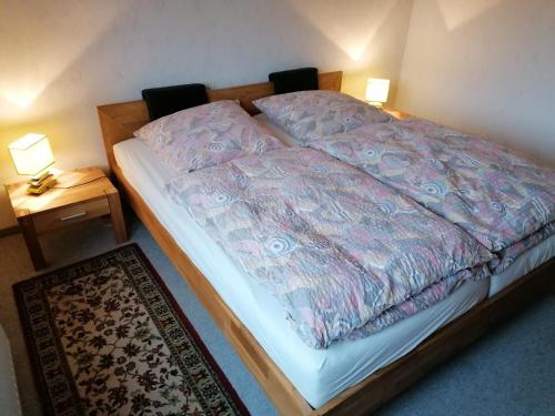 a bed in a room with two lamps and a rug at Ferienwohnung Wiesenweg in Bad Bederkesa