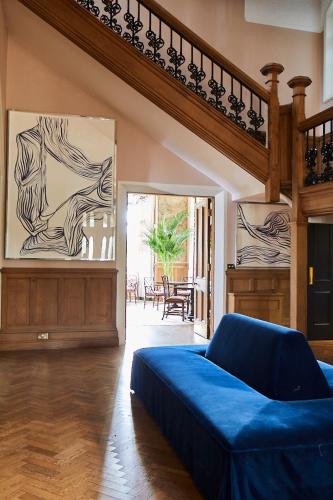 a living room with a blue bed and a staircase at Oakley Court in Windsor