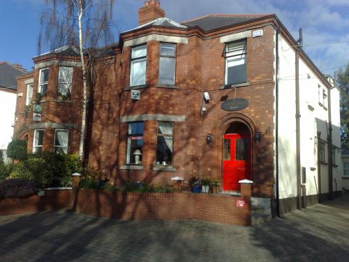 una vieja casa de ladrillo con una puerta roja en Ashling House Serviced Accommodation, en Dublín