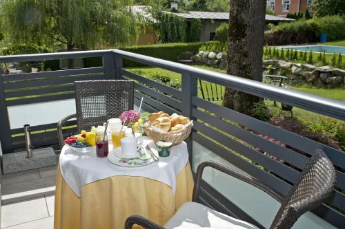 una mesa con una cesta de comida en el balcón en Villa Berginz by Seebnb, en Velden am Wörthersee