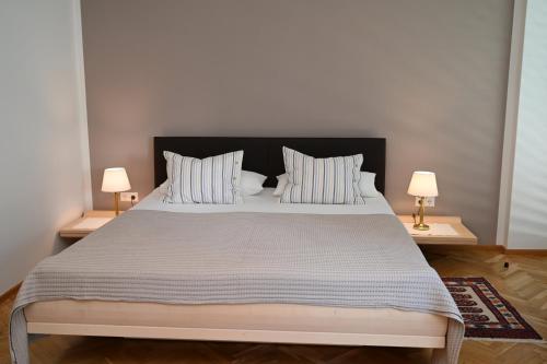 1 dormitorio con 1 cama grande y 2 lámparas en Villa Berginz by Seebnb, en Velden am Wörthersee