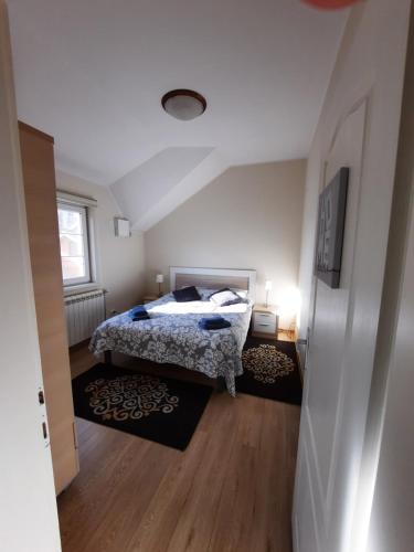 a bedroom with a bed and two rugs at Dream apartments in Novi Sad