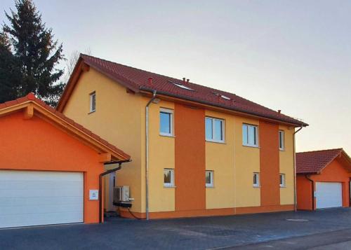 a yellow and orange house with a garage at Gästehaus Traunreut - Monteur und Gästezimmer - in Traunreut