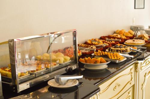 a buffet with many different types of food on a counter at Pousada Tango in Gramado