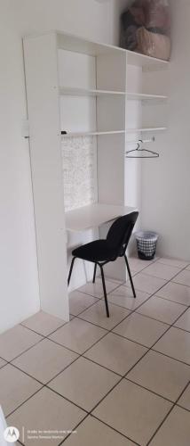 a black chair in a white room with a table at Hotel Norte Blu in Blumenau