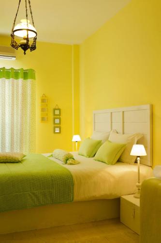 a bedroom with a large bed with yellow walls at Senses Boutique Hotel in Imerovigli