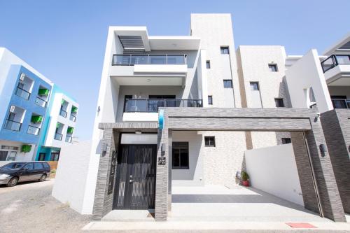 a large white building with a garage at Huayu Homestay in Magong