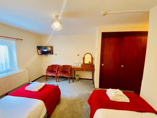 a room with two beds and a desk and a table at Mount Pleasant Hotel in Oxford