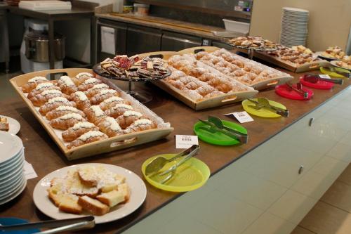 un buffet con varias bandejas de comida en una mesa en Hotel Mediterraneo, en Montesilvano