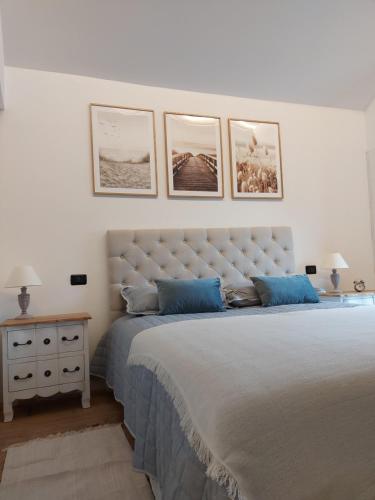 a bedroom with a large bed with three pictures on the wall at Le Allegre Comari di Ossuccio in Ossuccio