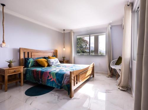 Schlafzimmer mit einem Bett und einem Fenster in der Unterkunft Peponi SelfCatering Apartments in Beau Vallon