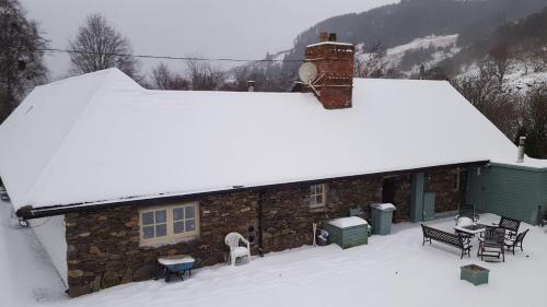a house with snow on the roof of it at Clarisses Cottage in Laragh