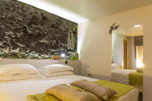 a bedroom with two beds and a painting on the wall at Graviana - Pedra Lima Charming House in Lagoa