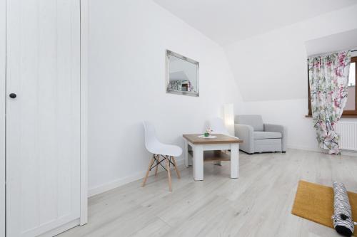 a white living room with a table and a chair at Krab in Rewal
