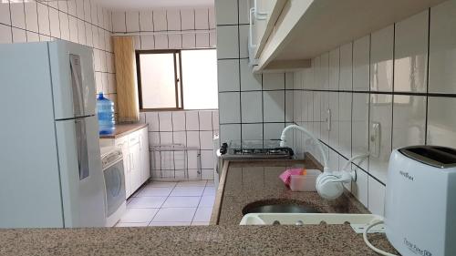 Una pequeña cocina con fregadero y refrigerador. en Apto em prédio frente ao mar, Meia Praia Itapema, linda vista, 3 dormitórios, en Itapema