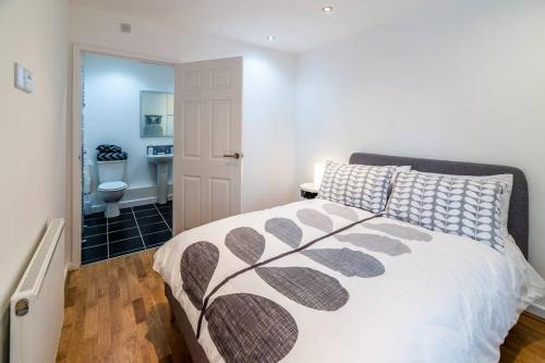 a bedroom with a bed and a bathroom with a toilet at Lady Bay Apartments in Nottingham